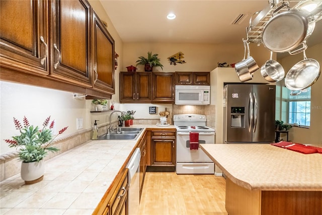 kitchen featuring white appliances, tile countertops, and sink