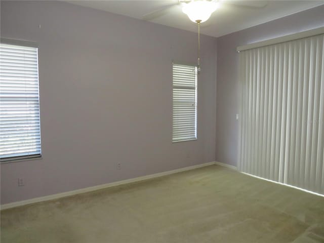 carpeted spare room featuring ceiling fan