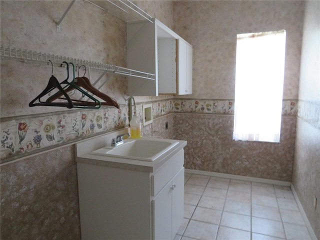 laundry room featuring sink and light tile patterned floors