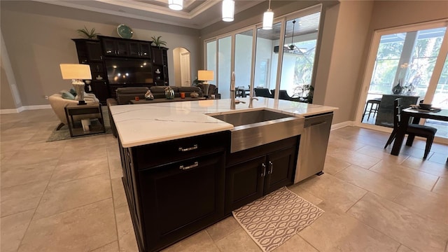 kitchen with pendant lighting, light tile floors, dishwasher, a center island with sink, and light stone countertops