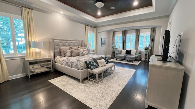 bedroom with multiple windows, dark hardwood / wood-style floors, a tray ceiling, and ornamental molding