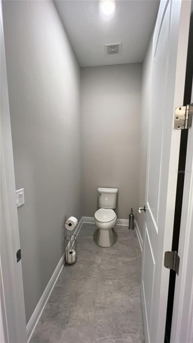 bathroom featuring toilet and tile floors