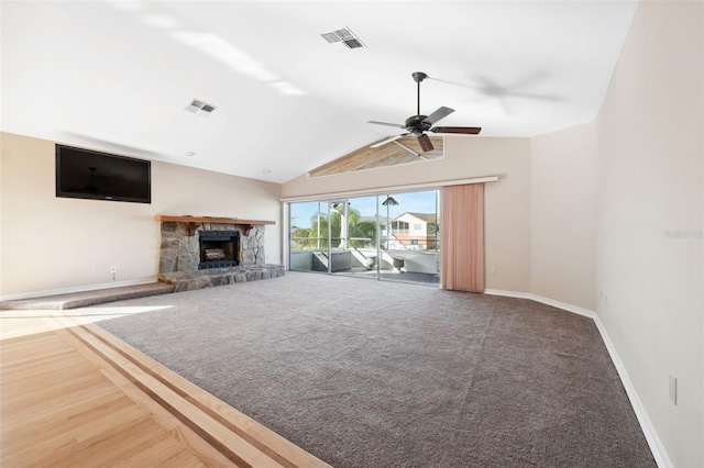 unfurnished living room with carpet, vaulted ceiling, ceiling fan, and a fireplace