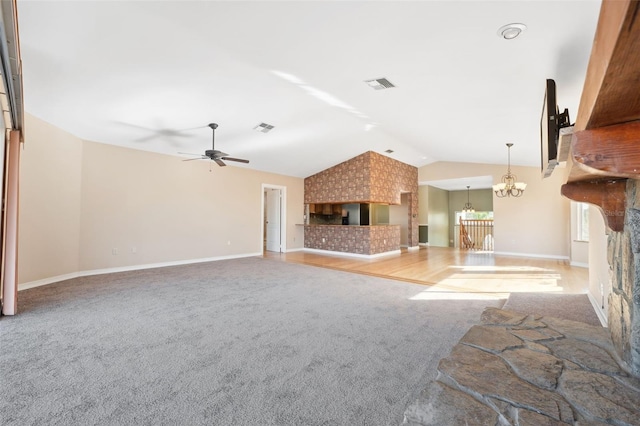 unfurnished living room featuring a multi sided fireplace, ceiling fan with notable chandelier, vaulted ceiling, and light colored carpet