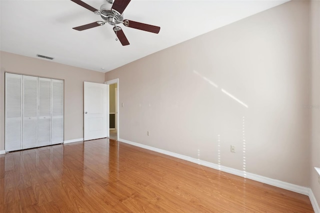 unfurnished bedroom featuring light hardwood / wood-style floors, a closet, and ceiling fan