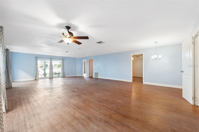 empty room with dark hardwood / wood-style floors and ceiling fan with notable chandelier