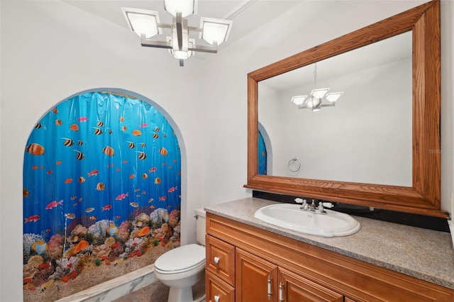 bathroom with toilet, tile flooring, vanity, and an inviting chandelier