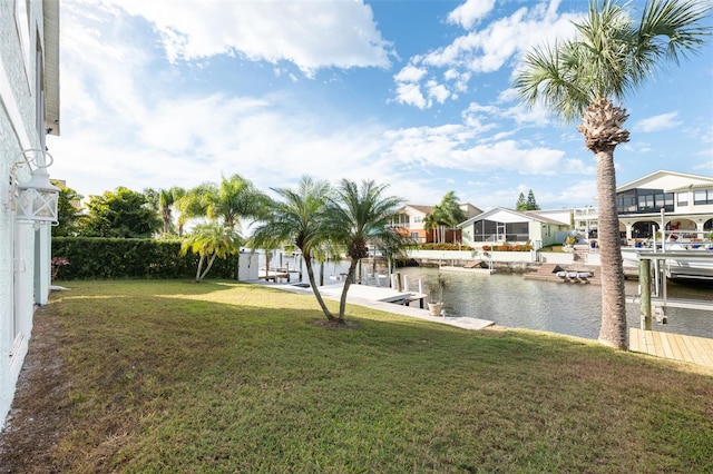 view of dock with a water view and a yard