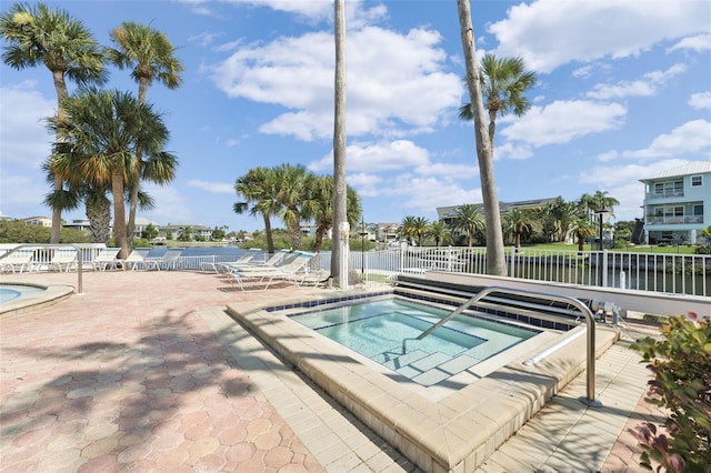 view of swimming pool featuring a community hot tub and a patio