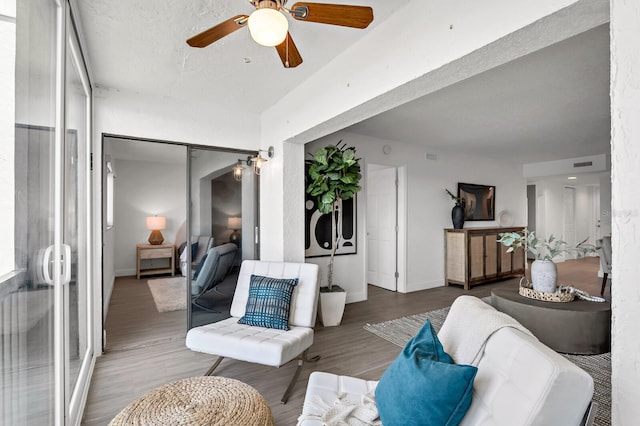 living room featuring wood-type flooring and ceiling fan