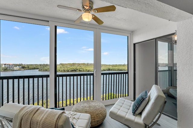 sunroom / solarium featuring a water view, ceiling fan, and a healthy amount of sunlight