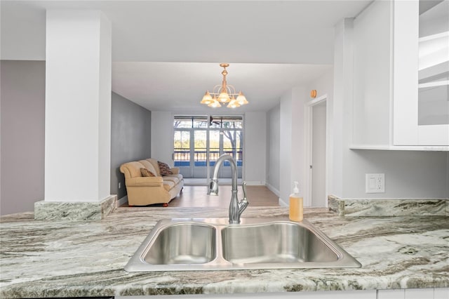 kitchen featuring sink, pendant lighting, and a chandelier