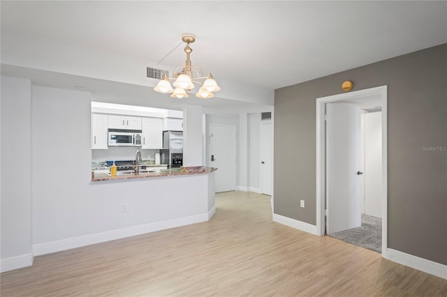 kitchen with a notable chandelier, white cabinets, stainless steel fridge with ice dispenser, decorative light fixtures, and kitchen peninsula