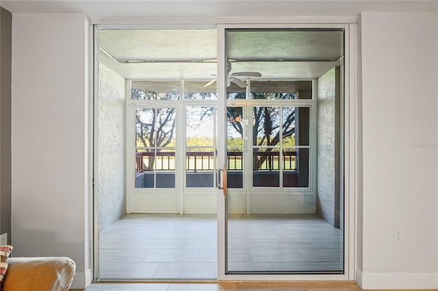 entryway featuring expansive windows and ceiling fan