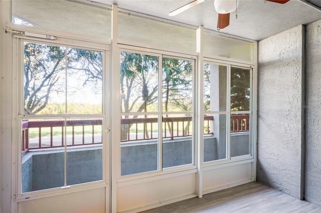 unfurnished sunroom with a healthy amount of sunlight and ceiling fan