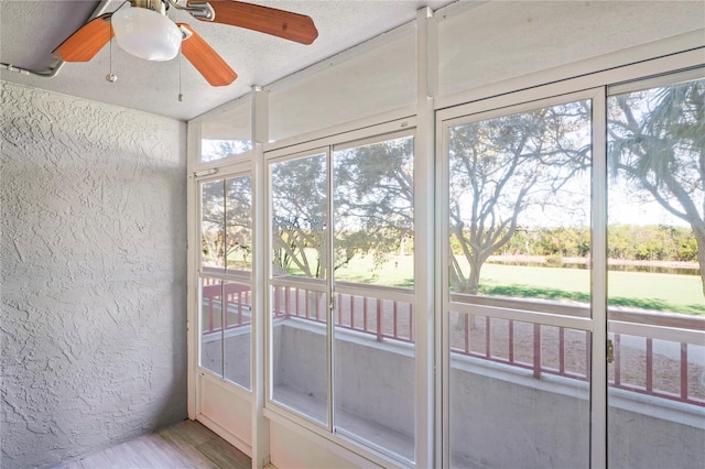 unfurnished sunroom featuring ceiling fan