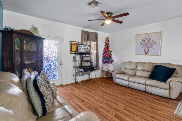 living room featuring wood-type flooring and ceiling fan