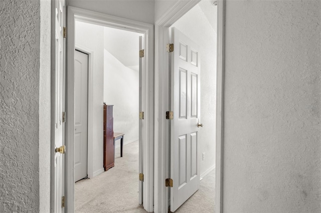 hallway featuring light carpet