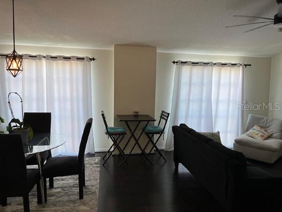 dining space with ceiling fan and dark wood-type flooring