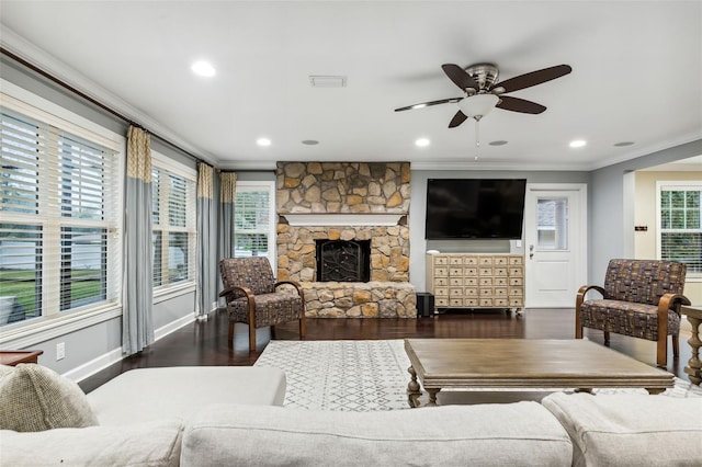 living room with a fireplace, ornamental molding, ceiling fan, and dark wood-type flooring