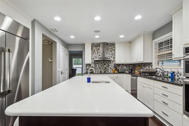 kitchen featuring sink, wall chimney exhaust hood, a spacious island, and stainless steel appliances