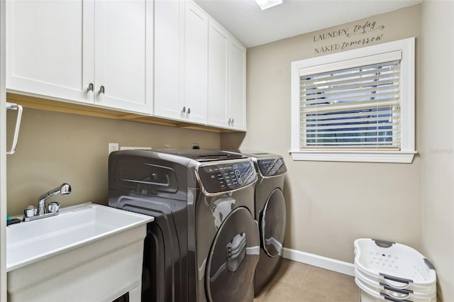 laundry area featuring light tile patterned flooring, cabinets, sink, and washing machine and clothes dryer