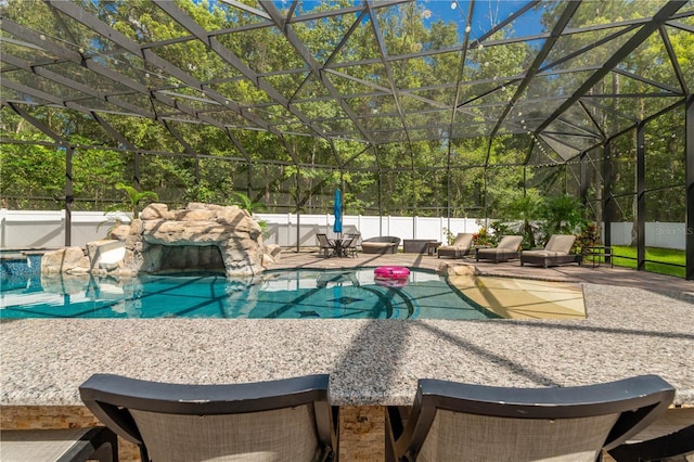 view of swimming pool with pool water feature, a lanai, and a patio area