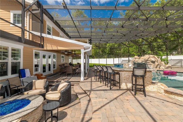 view of patio / terrace with ceiling fan, a fenced in pool, and an outdoor bar