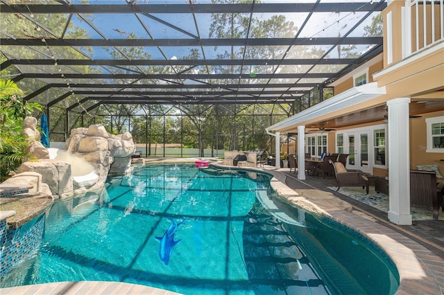 view of swimming pool featuring ceiling fan, an outdoor hangout area, glass enclosure, and french doors