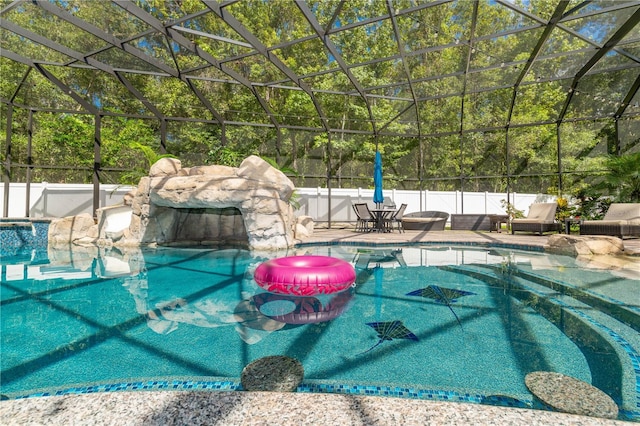 view of pool with glass enclosure and a patio area