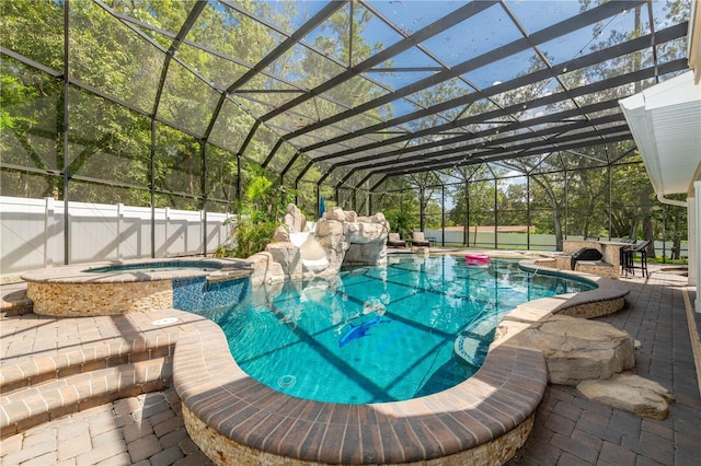 view of pool with a lanai, an in ground hot tub, and a patio