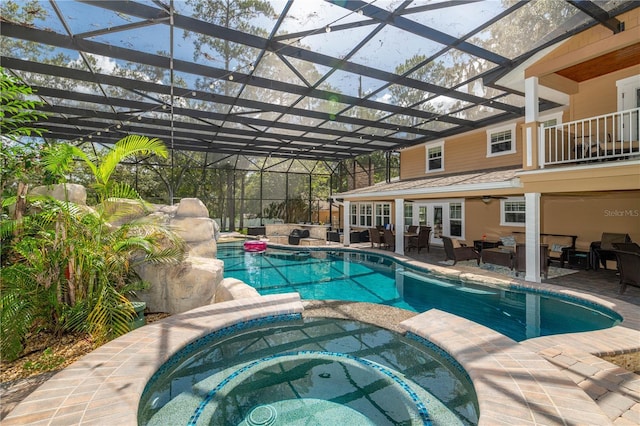 view of swimming pool with a lanai, a patio area, and an in ground hot tub