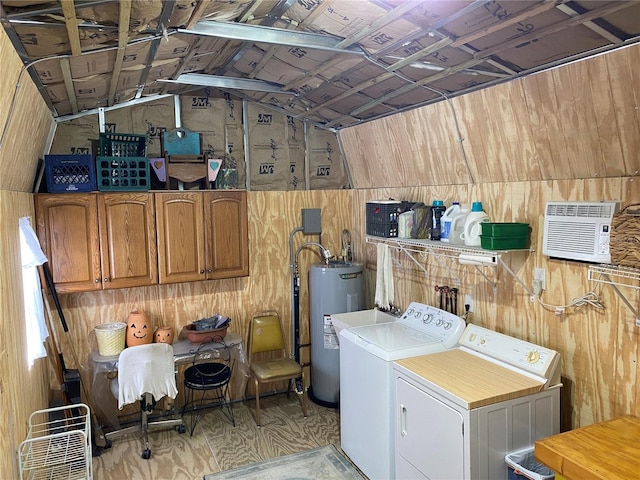 clothes washing area featuring cabinets, electric water heater, wood walls, and independent washer and dryer