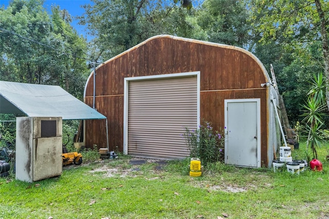 view of outdoor structure featuring a lawn and a garage