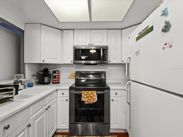 5108 Amulet Dr Unit 206, New Port Richey, FL 34652 - kitchen with appliances with stainless steel finishes, dark hardwood / wood-style floors, white cabinetry, and sink