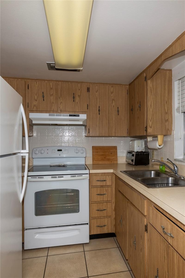 kitchen with light tile floors, tasteful backsplash, white appliances, and sink