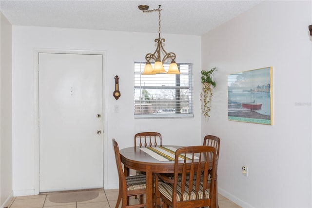 tiled dining room with an inviting chandelier and a textured ceiling