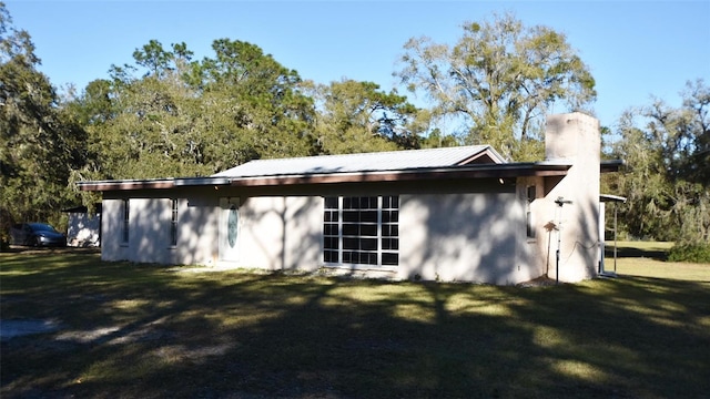 rear view of house featuring a lawn