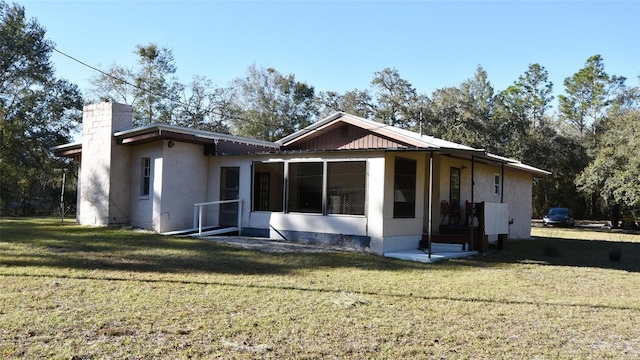 rear view of house featuring a lawn