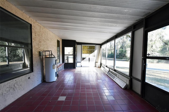 unfurnished sunroom featuring water heater and a healthy amount of sunlight