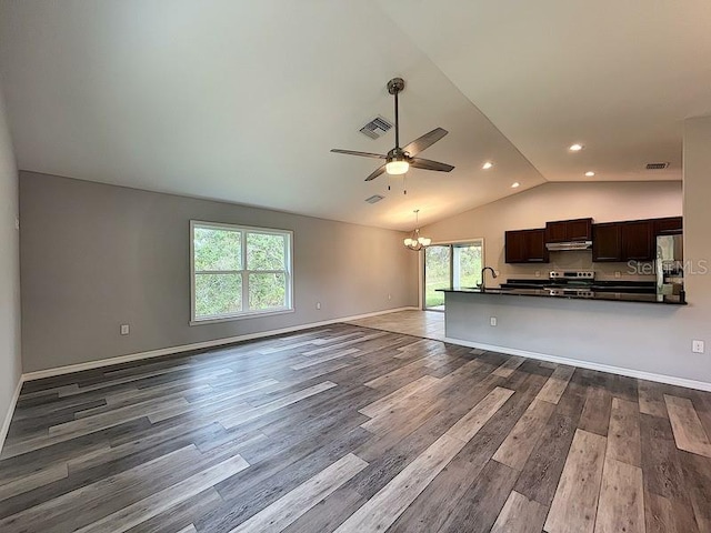 unfurnished living room with ceiling fan with notable chandelier, lofted ceiling, sink, and hardwood / wood-style floors