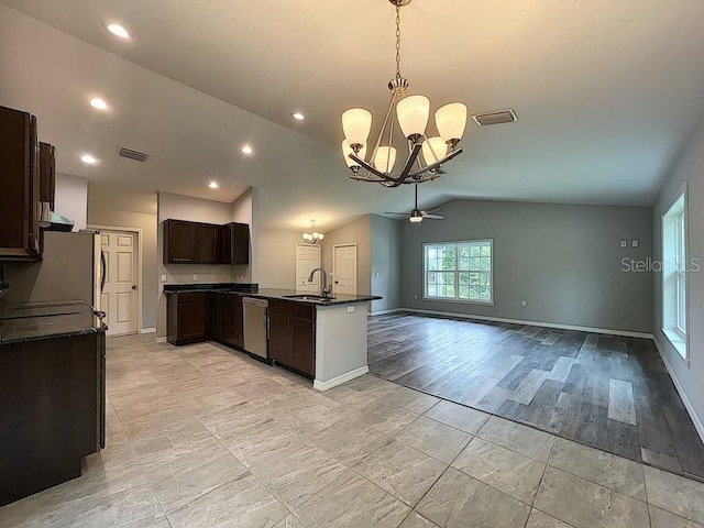 kitchen with pendant lighting, sink, appliances with stainless steel finishes, ceiling fan with notable chandelier, and vaulted ceiling