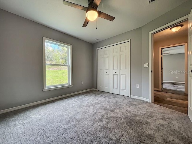 unfurnished bedroom with ceiling fan, carpet flooring, and a closet