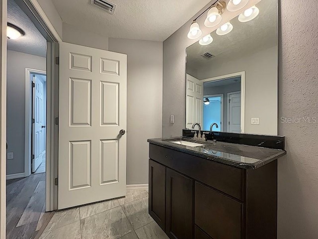 bathroom with vanity and a textured ceiling