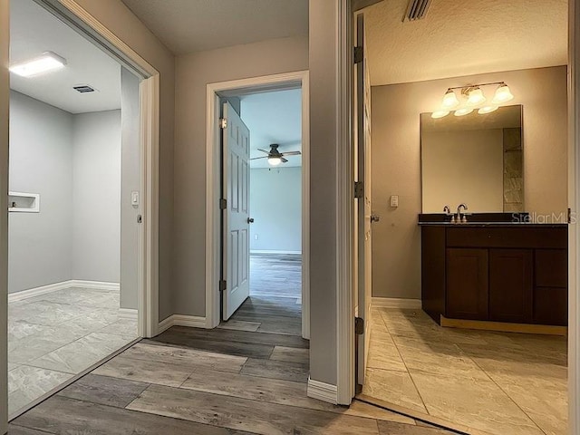 hallway with sink and light hardwood / wood-style flooring