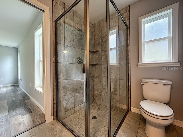 bathroom with toilet and an enclosed shower