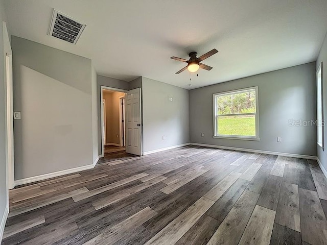 empty room with dark hardwood / wood-style floors and ceiling fan