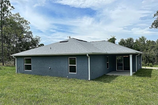 back of property with a lawn and a patio area