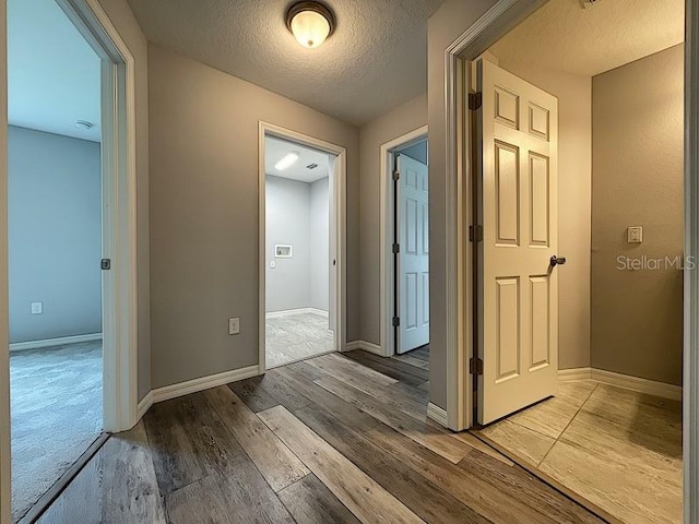 hallway featuring hardwood / wood-style floors and a textured ceiling