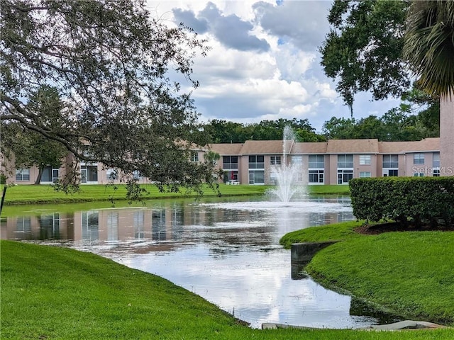 view of property's community featuring a lawn and a water view